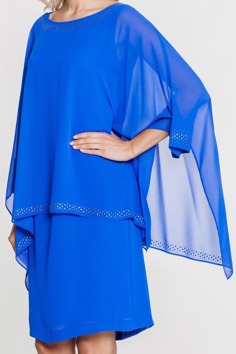 Modelka prezentuje kobaltową sukienkę z szyfonu marki Vito Vergelis. Rękaw z ozdobną naklejką.
