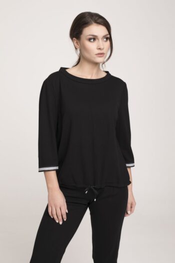 Modelka w czarnym dresie z lampasami Vito Vergelis. Czarna bluza ze stójką i taśmami i czarne spodnie Vito Vergelis.