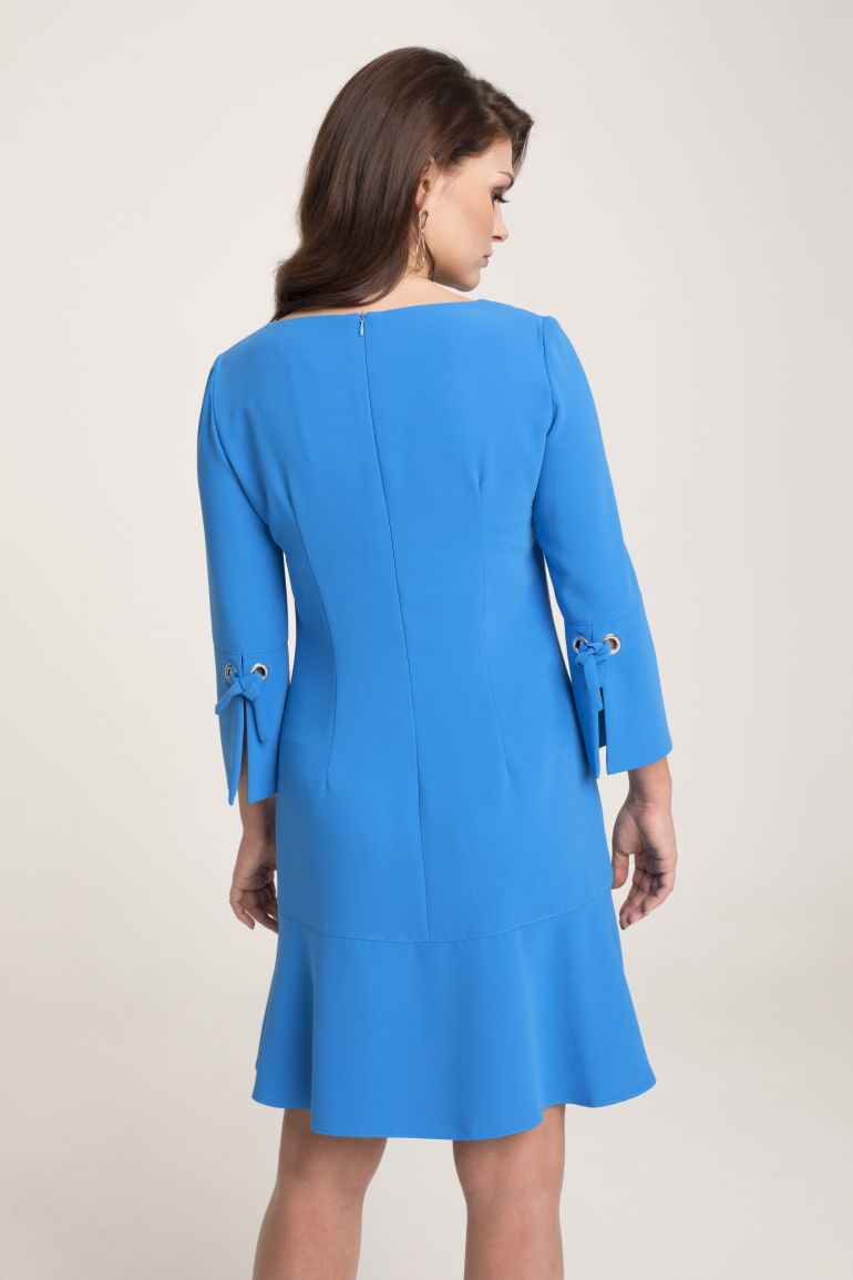 Modelka w sukience Vito Vergelis. Niebieska sukienka z falbaną i wiązaniami przy rękawach.