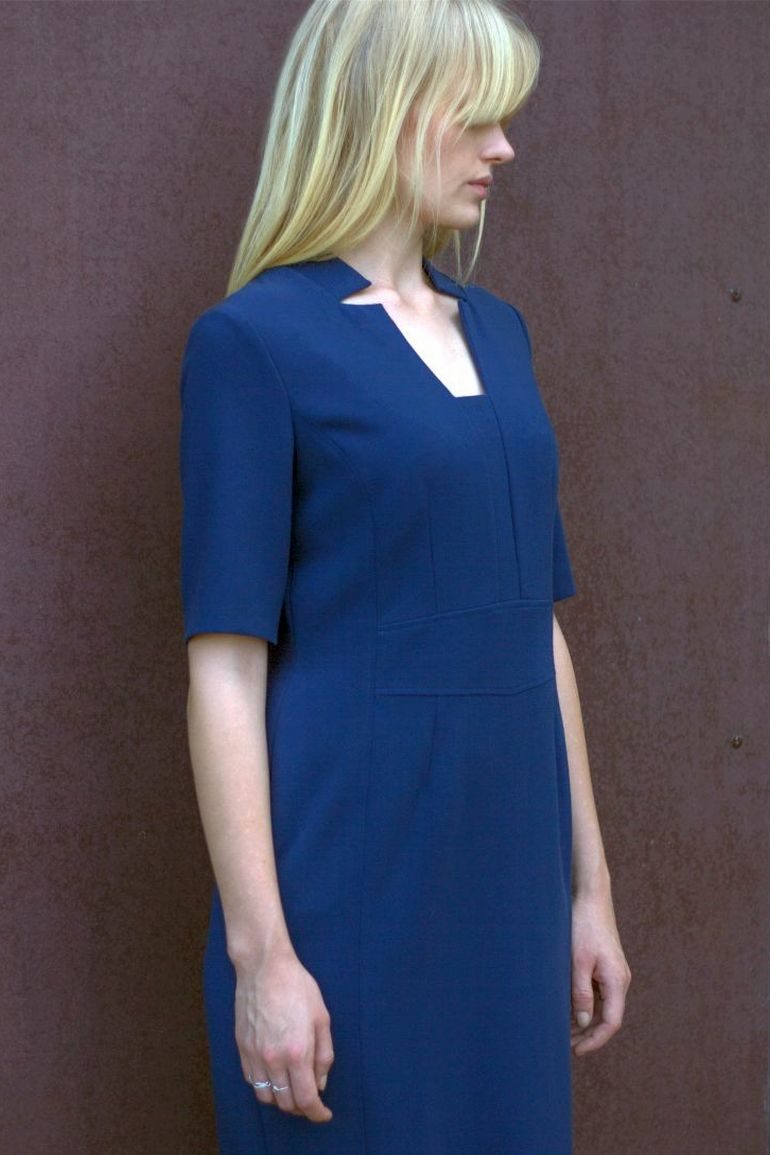 Modelka w sukience Vito Vergelis. Niebieska sukienka biznesowa z cięciami.