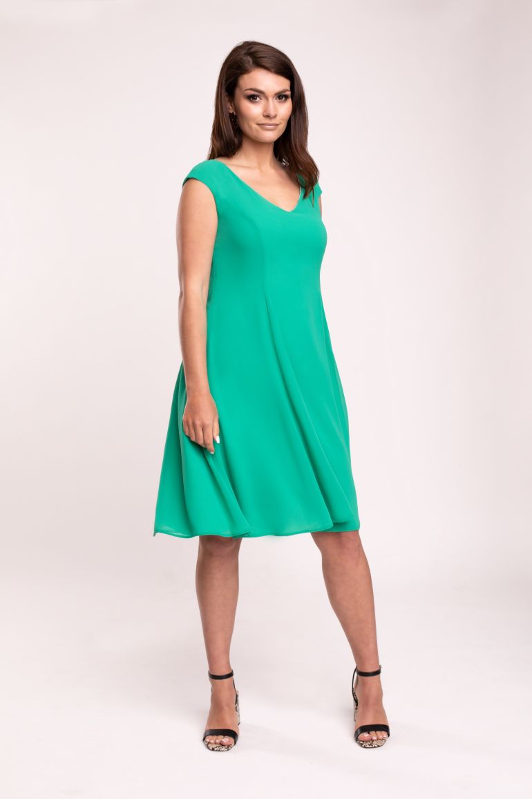 Modelka prezentuje sukienkę marki Vito Vergelis. Zielona sukienka z szyfonu z rozkloszowanym dołem i dekoltem V.