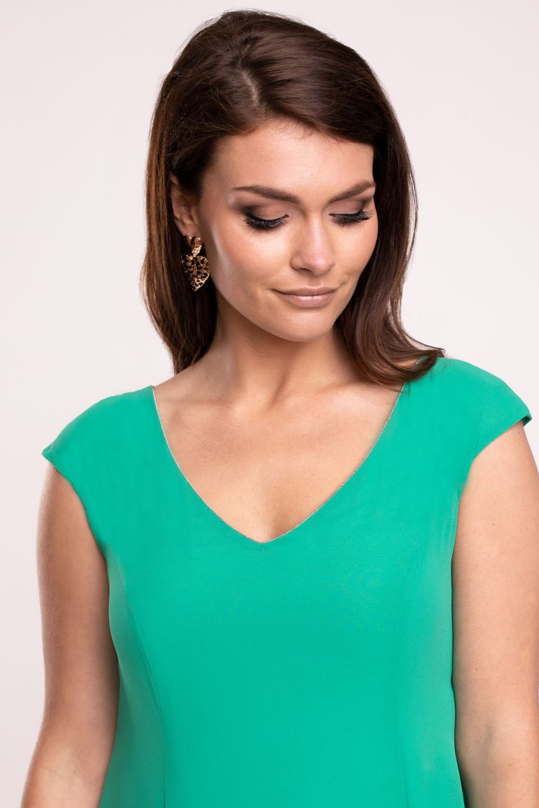 Modelka prezentuje sukienkę marki Vito Vergelis. Zielona sukienka z szyfonu z dekoltem V.